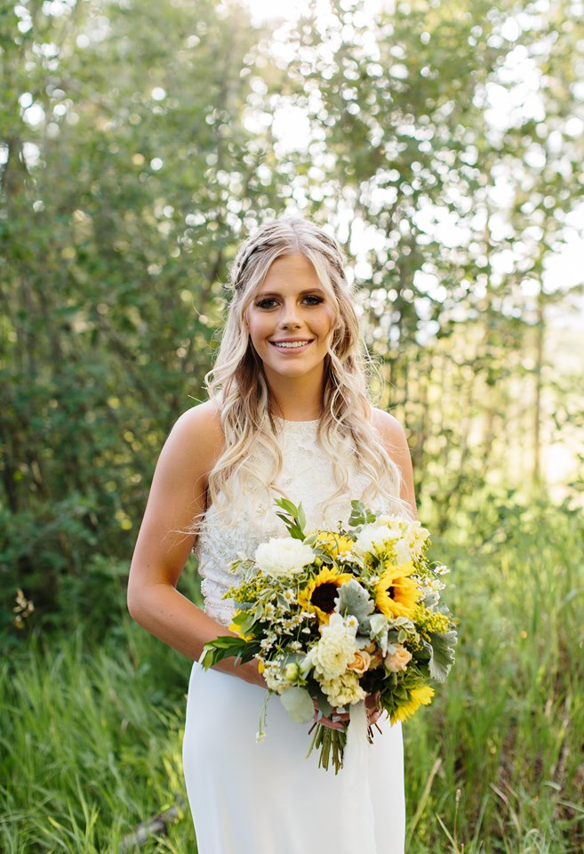 Summer bride with sunflower bouquet in the mountain